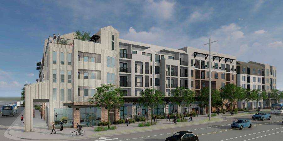 Modern multi-story residential building with large windows, balconies, and a roof terrace. The ground floor has retail spaces and the street is busy with cars, bicycles, and pedestrians.