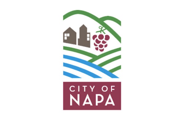 City of Napa logo with stylized hills, two buildings, a bunch of grapes, and blue lines representing fields above a red box reading "City of Napa.